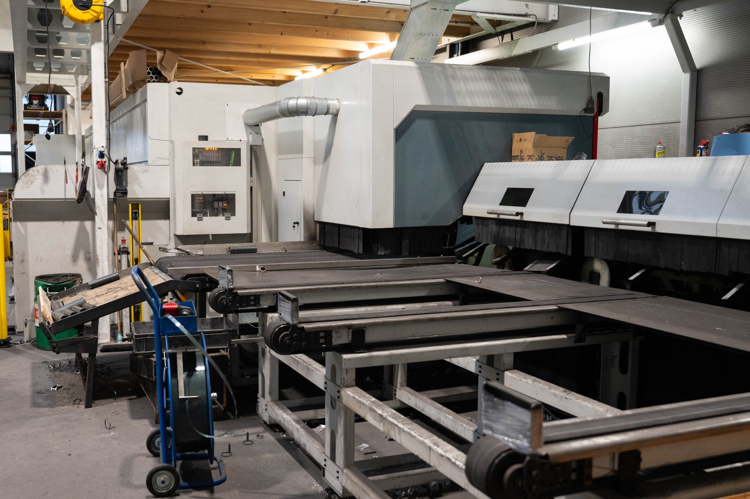 De buislaser met afvoerband in de productiehal